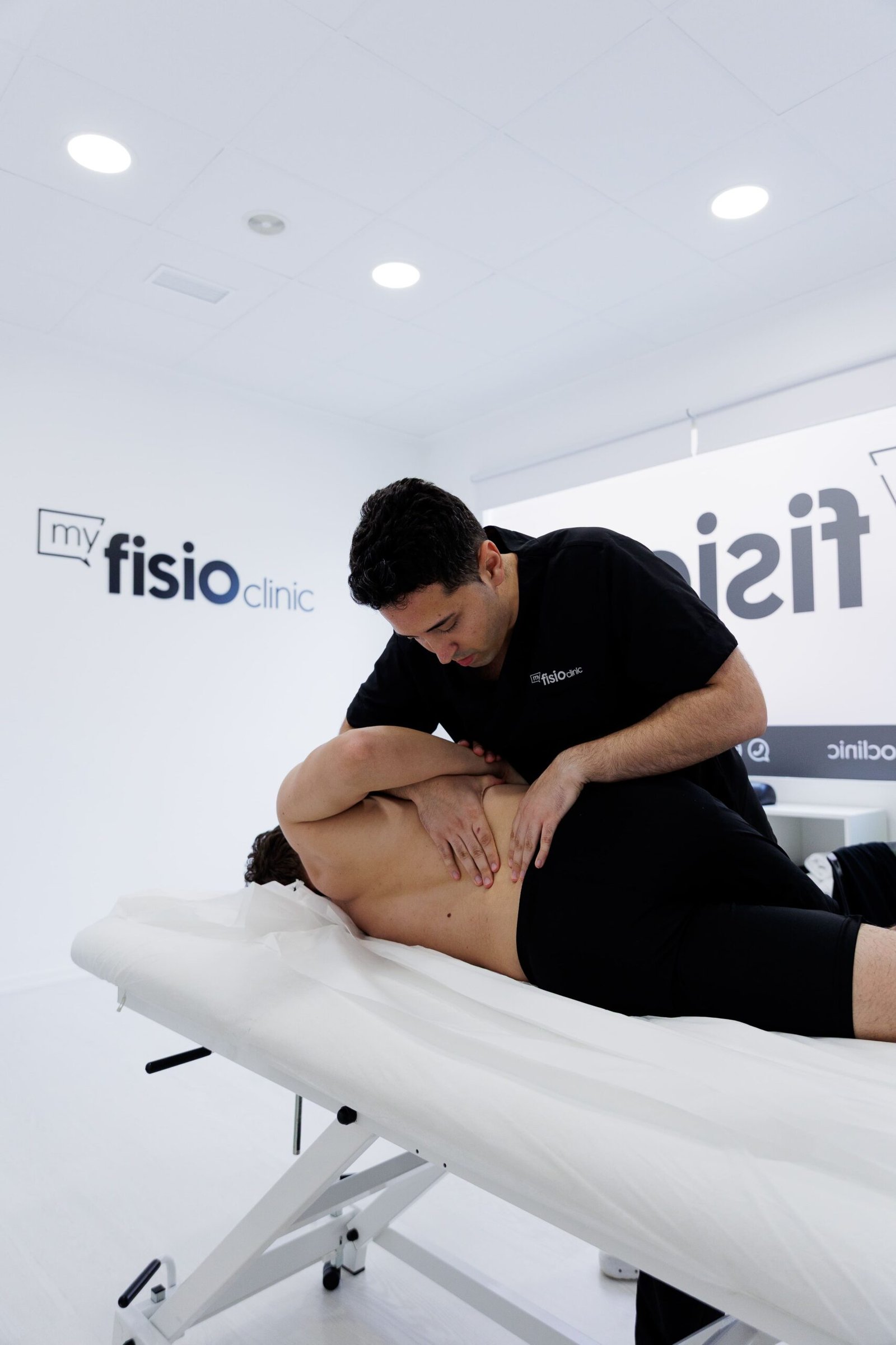 Fisioterapeuta aplicando terapia manual en la espalda de un paciente en My Fisio Clinic, Vila-real