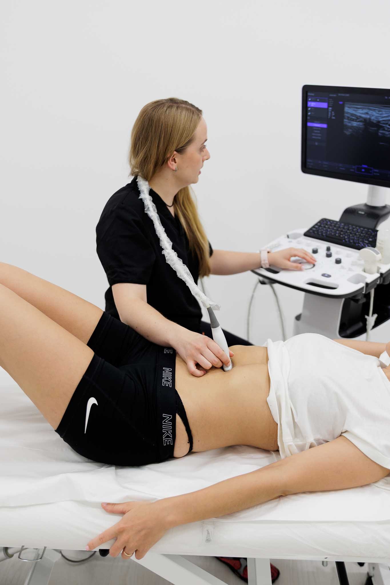 Fisioterapeuta haciendo una valoración con ecografía abdominal a una paciente en la recuperación postparto, Vila-real